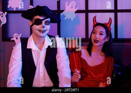 Jeune couple en costumes à la fête d'Halloween Banque D'Images