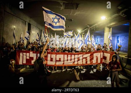 Jérusalem, Israël. 11 septembre 2023. Des manifestants défilent en brandissant des drapeaux israéliens et une banderole en hébreu « la cour est suprême » lors d'une manifestation à Jérusalem. Des milliers de manifestants anti-gouvernementaux israéliens se sont rassemblés devant la Cour suprême lundi, à la veille d'une audience historique sur une tentative de la coalition du Premier ministre Benjamin Netanyahu de restreindre les pouvoirs de la Cour. (Image de crédit : © Eyal Warshavsky/SOPA Images via ZUMA Press Wire) USAGE ÉDITORIAL SEULEMENT! Non destiné à UN USAGE commercial ! Banque D'Images