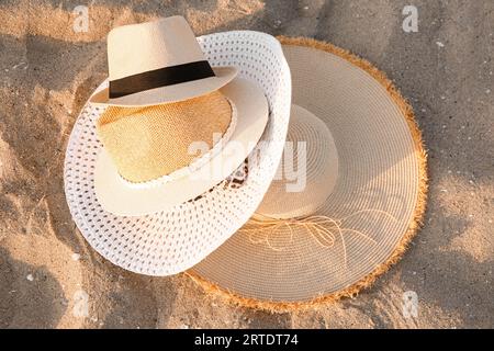 Ensemble de chapeaux de paille élégants sur sable Banque D'Images