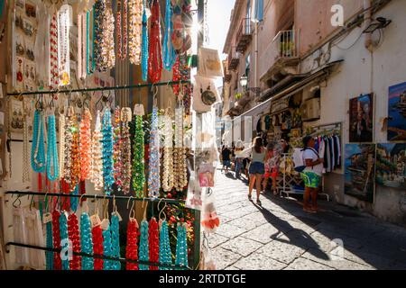 La vue le long de la via S Cesareo, une ruelle étroite bordée de boutiques touristiques dans le centre de Sorrente, en Italie. Sorrente est une ville côtière du sud-ouest de l'Italie, face à la baie de Naples sur la péninsule de Sorrente. Perché au sommet des falaises qui séparent la ville de ses ports de plaisance animés, il est connu pour ses vues panoramiques sur l'eau et la Piazza Tasso, une place bordée de cafés. Banque D'Images