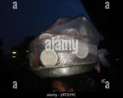 Dhaka, Bangladesh. 13 septembre 2023. Un vendeur de nourriture de rue a recouvert ses marchandises d'une feuille de plastique pour éviter la pluie à Dhaka. (Image de crédit : © MD Mehedi Hasan/ZUMA Press Wire) USAGE ÉDITORIAL SEULEMENT! Non destiné à UN USAGE commercial ! Banque D'Images