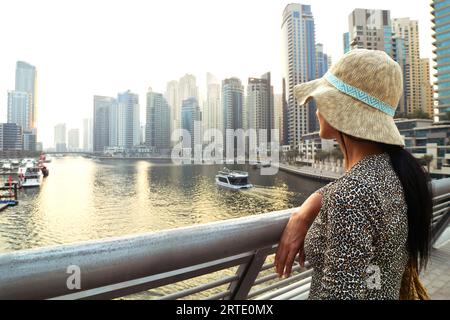 Dubaï, Émirats Arabes Unis - 12th octobre 2022 : magnifique touriste caucasienne en robe d'été à la mode Profitez de la marina de Dubaï dans les Émirats arabes Unis. Luxe et Banque D'Images