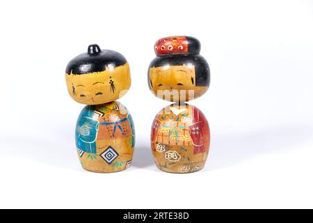 Vintage japonais peint en bois Kokeshi Folk groupe de poupées isolé sur un fond de studio blanc Banque D'Images
