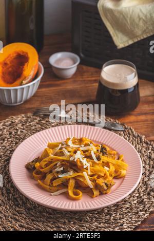 Pâtes de fettuccine avec sauce à la citrouille et champignons garnis de parmesan râpé Banque D'Images