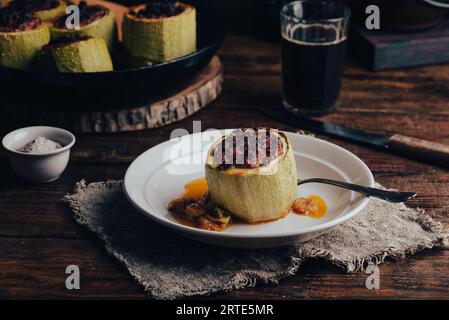 Portion de courgettes cuites au four farcies de viande hachée et d'herbes sur assiette Banque D'Images