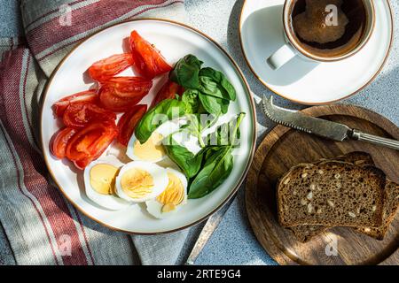 Petit déjeuner sain avec légumes frais, œufs durs, pain et une tasse de café Banque D'Images