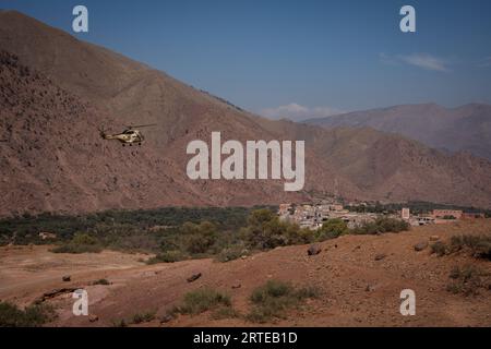 Un hélicoptère participant aux opérations de sauvetage est vu voler vers le village de Talat n'Yaaqoub. Les sauveteurs locaux et internationaux sont sur leur dernière strade de leur mission dans le village de Talat n’Yaaqoub, épicentre du désastreux tremblement de terre au Maroc et au sud de Marrakech, alors que les « 72 heures dorées » pour sauver les survivants sont passées. Les villages de la région montagneuse de l'Atlas ont le plus souffert du tremblement de terre. Les membres de la famille de la victime accusés de l'accès difficile à la région montagneuse et de la lenteur de la réponse du gouvernement ont entravé l'effort de sauvetage. Banque D'Images