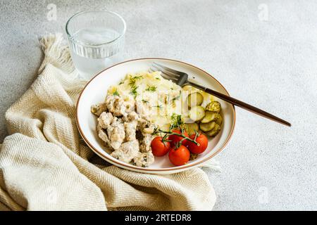 Tranches de porc dans une sauce à la crème sure avec purée de pommes de terre et légumes Banque D'Images