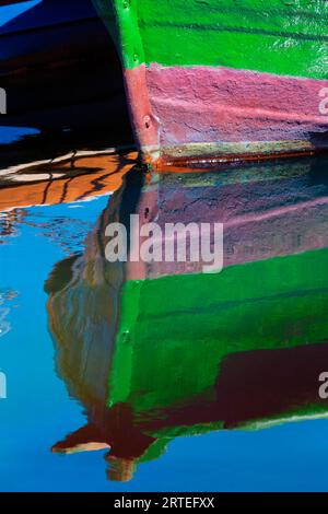 Détail d'un petit bateau de pêche en bois amarré au rivage avec un reflet d'image miroir dans l'eau calme dans la ville côtière de Getaria Banque D'Images