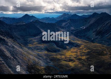 Vue aérienne des sommets montagneux accidentés et une vallée avec la toundra aux couleurs de l'automne dans le parc territorial Tombstone le long de la route Dempster dans le Yuk... Banque D'Images