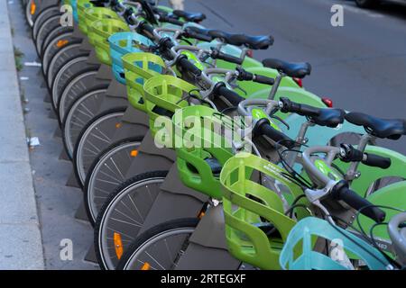 Vélos électriques garés en rangée le long de la rue, disponibles à la location à Paris ; Paris, France Banque D'Images