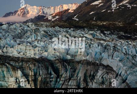 Gros plan sur le glacier Lamplugh et la lumière du soleil sur une chaîne de montagnes enneigée dans le parc national et réserve de Glacier Bay, Inside passage, Alaska, États-Unis Banque D'Images