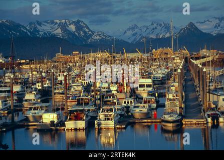 Port occupé plein de bateaux d'amarrage avec une chaîne de montagnes enneigées en arrière-plan en Alaska, États-Unis ; Alaska, États-Unis d'Amérique Banque D'Images