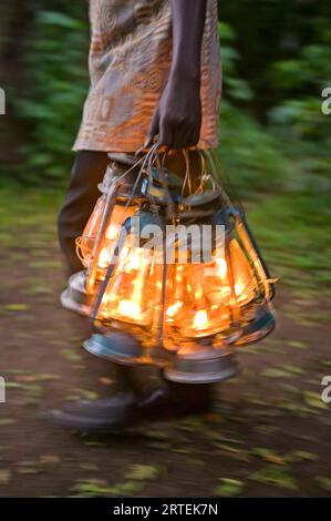 Transporter des lampes à kérosène éclairées ; Kenya Banque D'Images