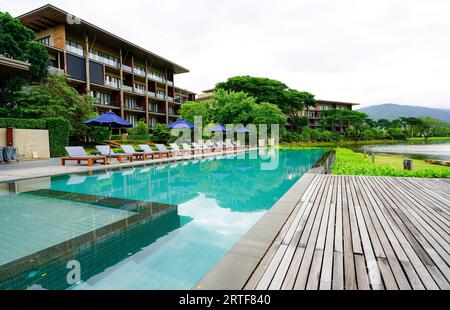 Paysage verdoyant de paradis tropical, les clients se livrent à une détente luxueuse au bord de la piscine bleue avec de l'eau sereine. Vacances d'été à l'hôtel de luxe. Banque D'Images