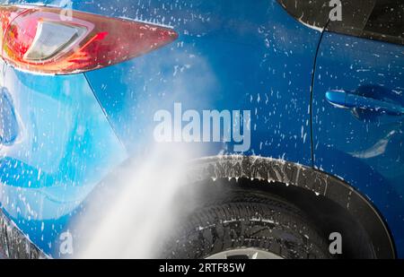 Lavage de voiture avec pulvérisation d'eau à haute pression. Nettoyage de voiture. Concept de service auto Care. Nettoyage de véhicules. Pulvérisation d'eau sur une voiture pour nettoyer la mousse blanche Banque D'Images