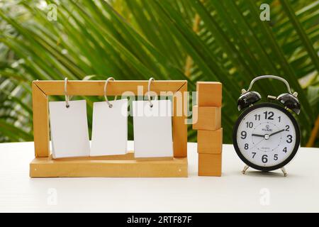 numéro 2023 sur un cube en bloc en bois et texte fiscal sur le cadre de support en papier avec réveil vintage sur la table avec fond de nature. Concept de temps d'imposition Banque D'Images