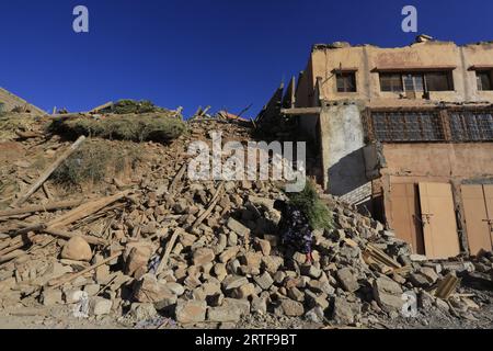 Al Haouz, Maroc. 12 septembre 2023. A les femmes marchent devant des bâtiments effondrés dans le village de montagne de Talat n'Yaaqoub après un tremblement de terre dans le sud de Marrakech. Al Haouz, Maroc, 12 septembre 2023. Le nombre de morts a continué de grimper à la suite du rare et puissant tremblement de terre de magnitude 6,8 qui a frappé le Maroc vendredi soir. Plus de 2 900 personnes sont confirmées mortes. Le séisme, le plus fort du Maroc depuis plus d'un siècle, a frappé la chaîne de montagnes du Haut Atlas du pays près de Marrakech. Photo de Youssef Boudlal/ABACAPRESS.COM crédit : Abaca Press/Alamy Live News Banque D'Images