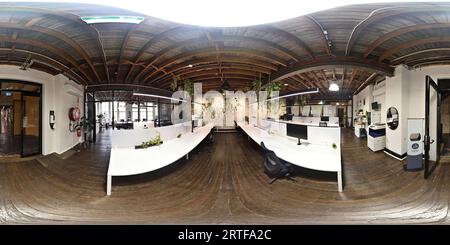 Vue panoramique à 360° de Panorama à 360° d'un espace de bureau de style Loft Hot Desking dans un ancien bâtiment d'usine, plancher en bois plafond à poutres apparentes