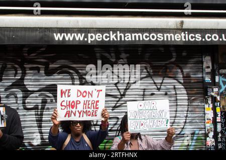 Londres, Royaume-Uni. 12 septembre 2023. Les manifestants brandissent des pancartes pendant la manifestation. Les manifestants se sont rassemblés devant la boutique Peckham Hair and Cosmetics autour d'une vidéo circulant sur les réseaux sociaux. La vidéo montre une bagarre entre une femme et le propriétaire masculin de Peckham Hair and Cosmetics, Sohail Sindho, 45 ans, qui semble avoir mis ses mains autour de sa gorge pendant l'altercation. Crédit : SOPA Images Limited/Alamy Live News Banque D'Images