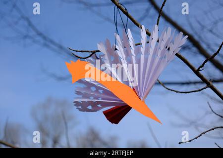 Oiseau en papier orange sur un arbre, origami Banque D'Images