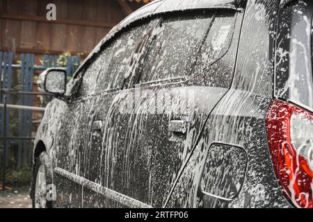 Klaten, Indonésie - août 17 2023 : une voiture grise est lavée dans une station de lavage en libre-service. Banque D'Images