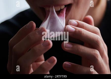 Berlin, Allemagne. 27 août 2023. Un enfant sort un chewing-gum collant de sa bouche avec ses mains. (Scène posée) crédit : Annette Riedl/dpa/Alamy Live News Banque D'Images