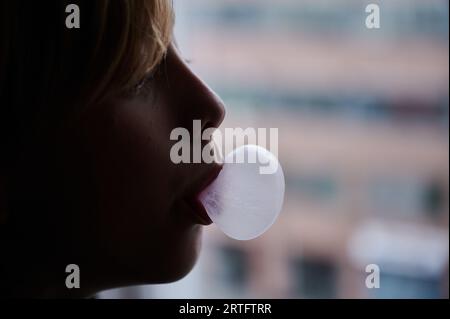 Berlin, Allemagne. 27 août 2023. Un enfant forme une bulle de chewing-gum avec sa bouche. (Scène posée) crédit : Annette Riedl/dpa/Alamy Live News Banque D'Images
