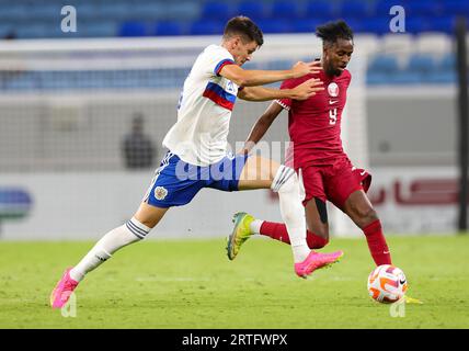 Al Wakrah. 13 septembre 2023. Yusuf Abdurisag (à droite) du Qatar rivalise avec Daniil Khlusevich, de Russie, lors du match amical de football entre le Qatar et la Russie au stade Al-Janoub à Al-Wakrah, au sud de Doha, Qatar, le 12 septembre 2023. Crédit : Nikku/Xinhua/Alamy Live News Banque D'Images