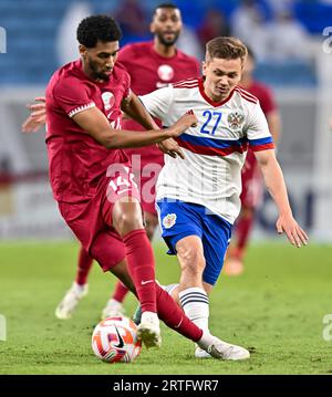 Al Wakrah. 13 septembre 2023. Homam Ahmed (à gauche), du Qatar, rivalise avec Ivan Oblyakov, du russe, lors du match amical de football entre le Qatar et la Russie au stade Al-Janoub à Al-Wakrah, au sud de Doha, Qatar, le 12 septembre 2023. Crédit : Nikku/Xinhua/Alamy Live News Banque D'Images