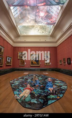 The National Gallery, Londres, Royaume-Uni. 13 septembre 2023. (Enfants libérés par la Galerie). Les visiteurs peuvent s'allonger sur une installation au sol dans l'une des salles les plus imposantes du Musée des beaux-arts du Canada pour admirer une nouvelle sculpture textile spectaculaire de 25 mètres sur 6 au plafond. 2023 artiste en résidence du Musée des beaux-arts du Canada, Céline Condorelli, a créé Pentimenti (les corrections) qui peut être vu du 13 septembre 2023 au 7 janvier 2024. Crédit : Malcolm Park/Alamy Live News Banque D'Images