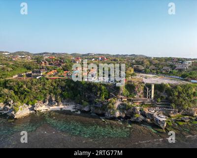 Vue aérienne de la falaise d'uluwatu, eau cristalline et ciel bleu Banque D'Images