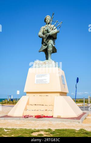 Statue au commando et pipe-pipe britanniques de la Seconde Guerre mondiale Bill Millin jouant des pipes en kilt, par le sculpteur Gaetan Ader, érigée sur la plage de Sword, en Normandie, en 2013. Banque D'Images