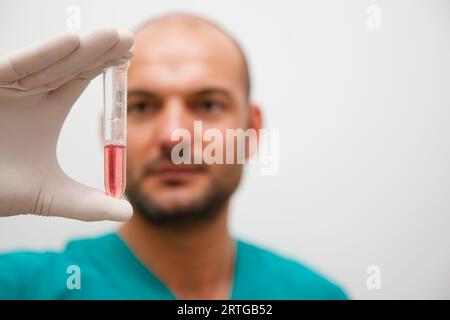 Professionnel de Santé tenant un tube à essai entre ses doigts Banque D'Images