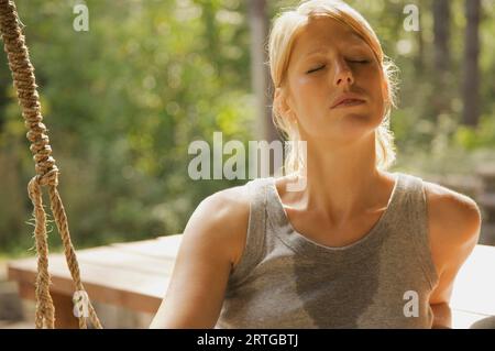Gros plan d'une jeune femme avec les yeux fermés en sueur Banque D'Images