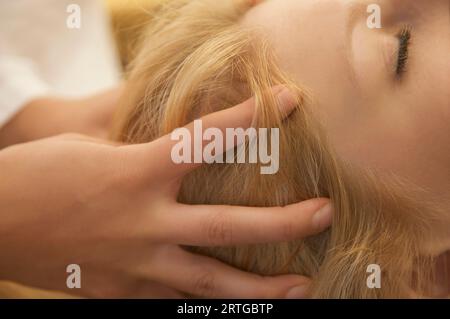 Extreme close up of woman chef recevoir massage du cuir chevelu Banque D'Images