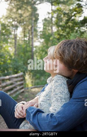 Profil d'un jeune couple assis et s'étreindre Banque D'Images