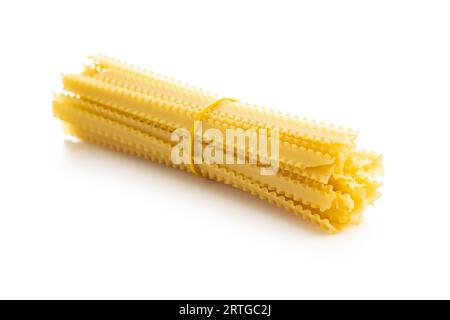 Pâtes de mafaldine non cuites. Pâtes mafalda longues crues isolées sur fond blanc. Banque D'Images