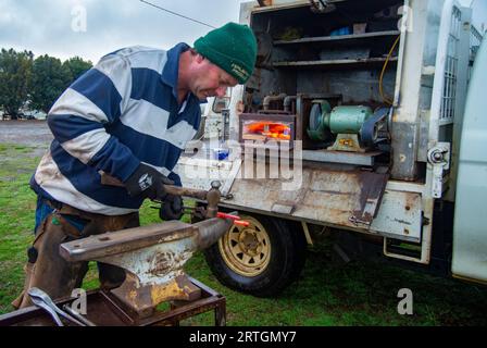 Porteur de chevaux, Craig Robotown utilisant une enclume portable et un four à gaz monté sur camion mobile pour secouer les fers à cheval tout en travaillant dans une école d'équitation près de Sorell, Tasmanie Banque D'Images