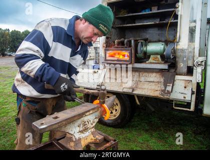 Porteur de chevaux, Craig Robotown utilisant une enclume portable et un four à gaz monté sur camion mobile pour secouer les fers à cheval tout en travaillant dans une école d'équitation près de Sorell, Tasmanie Banque D'Images