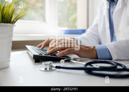 docteur tapant sur le clavier d'ordinateur. travailler dans le bureau de la clinique. consultation médicale en ligne et concept de e-santé Banque D'Images