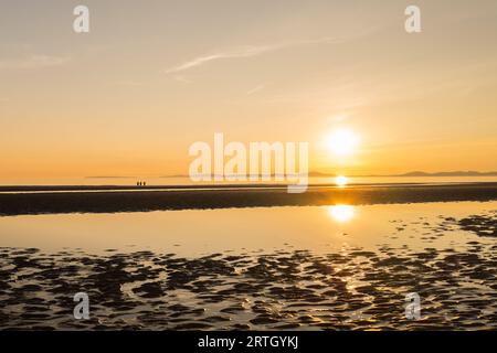 Coucher de soleil sur la plage de Harlech avec ciel bleu et mer calme. Banque D'Images