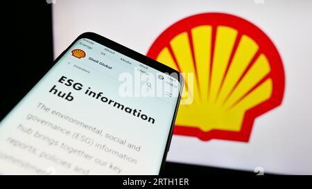 Téléphone portable avec le site Web de la société pétrolière et gazière britannique Shell plc à l'écran devant le logo de l'entreprise. Effectuez le focus sur le coin supérieur gauche de l'écran du téléphone. Banque D'Images