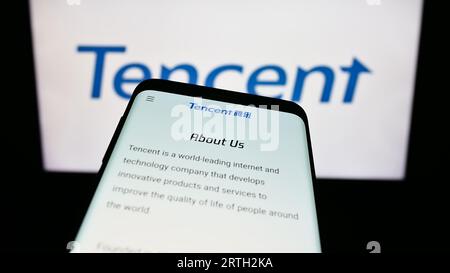 Smartphone avec le site Web de la société chinoise Tencent Holdings Ltd. Sur l'écran devant le logo de l'entreprise. Effectuez le focus sur le coin supérieur gauche de l'écran du téléphone. Banque D'Images