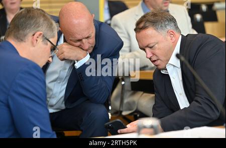 Erfurt, Allemagne. 13 septembre 2023. Thomas Kemmerich (M), porte-parole du groupe FDP, et Mario Voigt (CDU, r), président du groupe parlementaire, s'entretiennent avant le début d'une séance de questions-réponses au Parlement de Thuringe. Parmi les sujets abordés figurent l'augmentation du revenu des citoyens, la compétitivité de la Thuringe en tant que lieu d'affaires, la croissance économique en Thuringe, la demande d'énergie moins chère, de faibles impôts et moins de bureaucratie, ainsi que le soutien aux chômeurs et un changement de paradigme dans le système de transport public de Thuringe. Crédit : Martin Schutt/dpa/Alamy Live News Banque D'Images