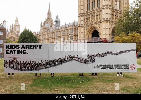 USAGE ÉDITORIAL ONLY Young Food Ambassadors for the Food Foundation manifestent à Westminster avec leur réinvention d’une affiche politique dans le cadre de la campagne « Feed the future », dans le but d’amener les politiciens à s’engager à étendre l’accès aux repas scolaires gratuits, comme 900 000 enfants vivant dans la pauvreté ne sont pas éligibles à ce régime. Date de la photo : mercredi 23 septembre. Banque D'Images