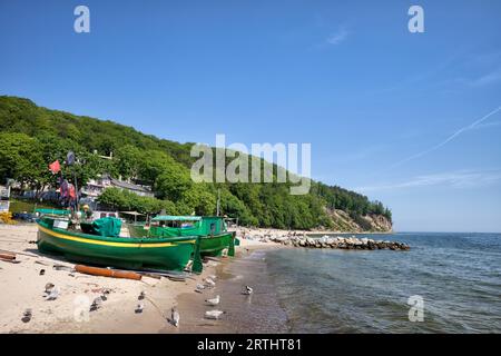 Plage avec bateaux de pêche à la baie de la mer Baltique dans la ville de Gdynia, district de Redlowo, Pologne, Europe, Orlowo Cliff à l'horizon Banque D'Images