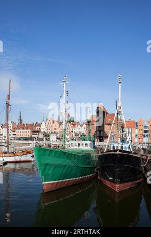 Les navires de pêche dans le port de Gdansk, Pologne, Vieille Ville skyline en arrière-plan Banque D'Images