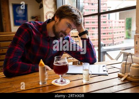 Un homme déprimé qui a perdu son emploi est venu dans un bar. Le concept d'alcoolisme et la lutte contre l'alcoolisme Banque D'Images