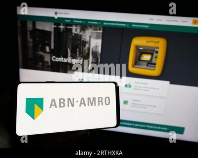 Personne détenant un téléphone portable avec le logo de la société financière néerlandaise ABN AMRO Bank N.V. sur l'écran devant la page Web de l'entreprise. Concentrez-vous sur l'affichage du téléphone. Banque D'Images